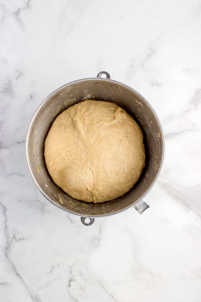 metal mixing bowl with dough for pumpkin sourdough cinnamon rolls after proofing
