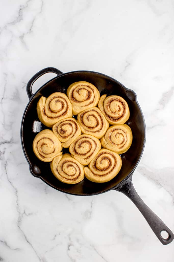 cast iron skillet with sourdough pumpkin cinnamon rolls before baking
