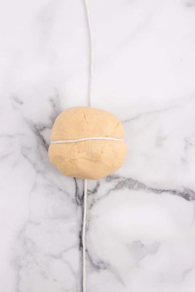 ball of dough being wrapped with kitchen string