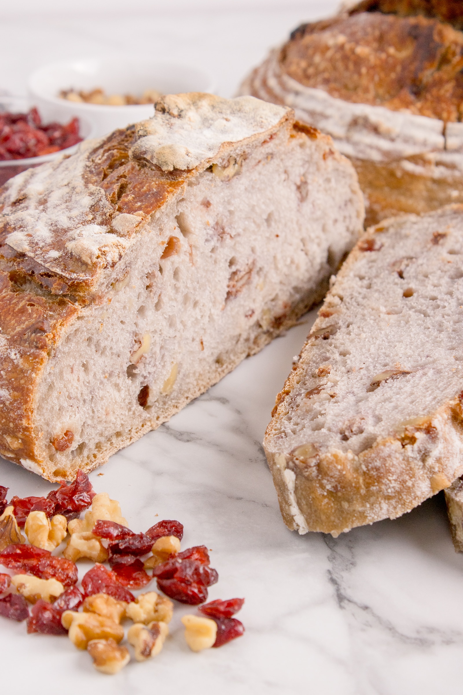 sourdough cranberry walnut loaf cut in half and stacked on each other