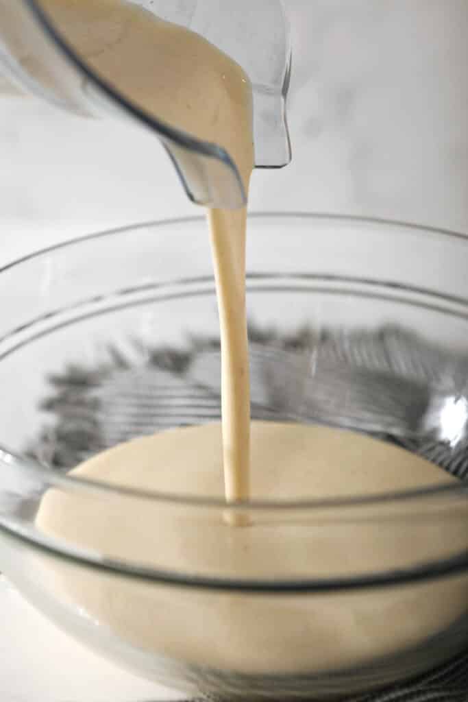 sourdough crepe batter being poured from blender into glass bowl
