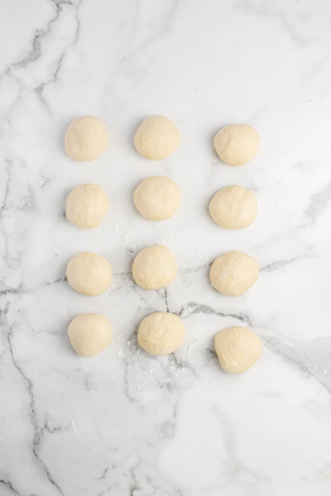12 balls of dough after shaping for donuts
