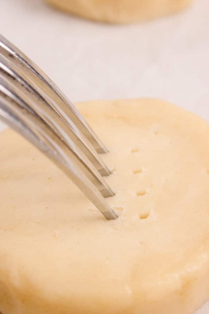 fork poking holes into cookie